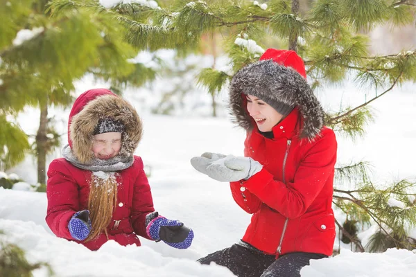 Ritratto di madre e figlioletta giocare e sorridere nella neve in legno — Foto Stock