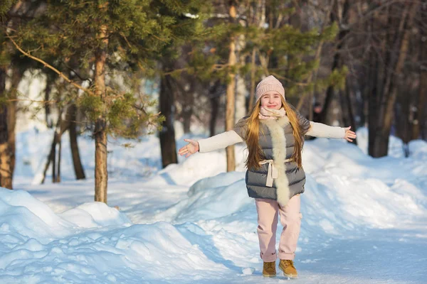 Petite fille en veste grise joue dans un parc en hiver — Photo