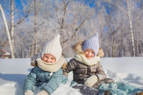 Ritratto di due bambine sedute e sorridenti in una giornata invernale — Foto Stock