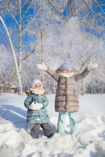 Due bambine in piedi e vomitare una neve in inverno — Foto Stock