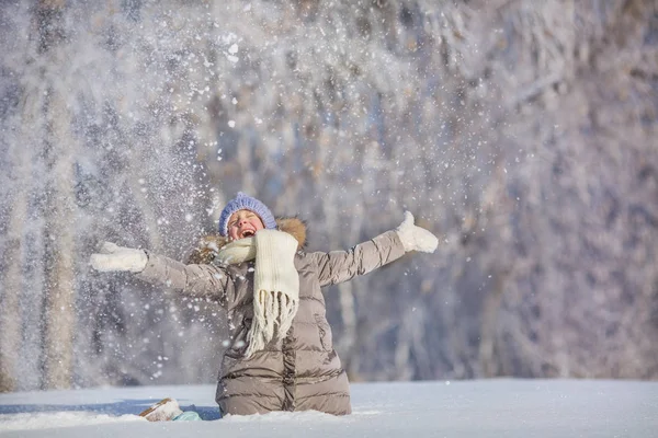 Bambina getta la neve e ride in inverno — Foto Stock