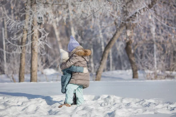 Due sorelline si abbracciano nella neve in inverno — Foto Stock