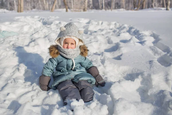 Ritratto di bambino seduto sulla neve in inverno — Foto Stock