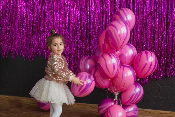Szép kislány, rózsaszín léggömbökkel játszik — Stock Fotó