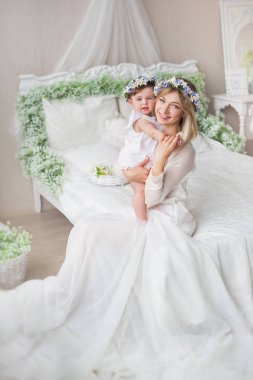 Mutlu genç anne ile küçük bebeği bir yatak odasında