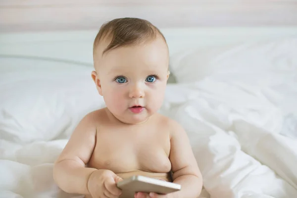 Bir elinde bir akıllı telefon ile oldukça küçük bebek portresi — Stok fotoğraf