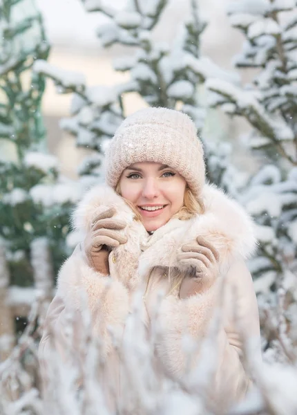 A téli spruces háttérképet mosolygó csinos lány portréja Stock Fotó