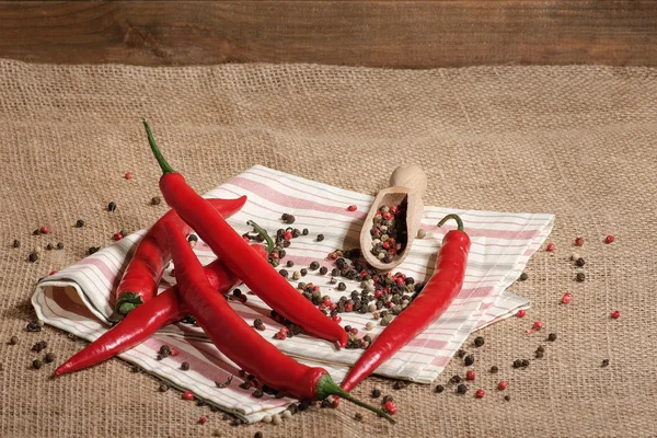 Ahşap torbalama artalanları ahşap ölçme kaşık ile üzerinde kırmızı sıcak biber