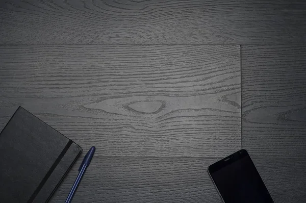 Defter, kalem, cüzdan, cep telefonu ile gri ahşap arka plan