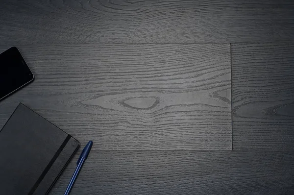 Defter, kalem, cüzdan, cep telefonu ile gri ahşap arka plan