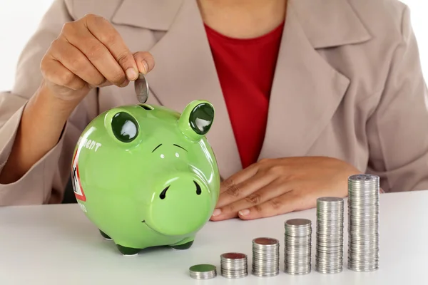 Mulher de negócios feliz com pilha de moedas e banco porquinho — Fotografia de Stock