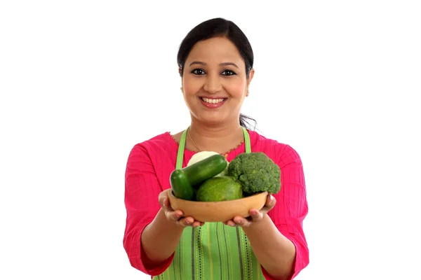 Usmívající se žena kuchař drží misku plnou zeleniny a ovoce — Stock fotografie