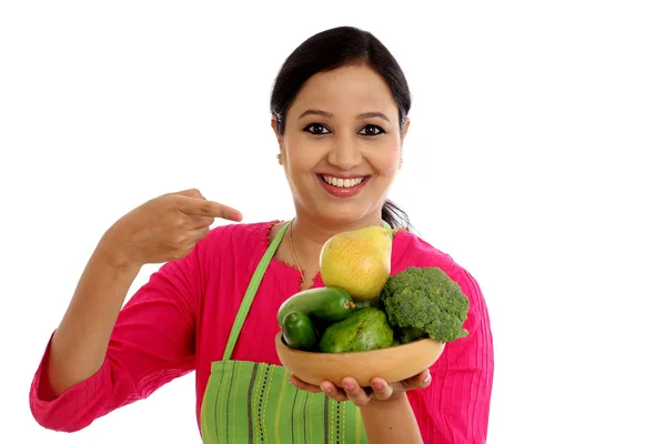 Uśmiecha się kobieta kucharz trzyma naczynie pełne warzyw i owoców — Zdjęcie stockowe