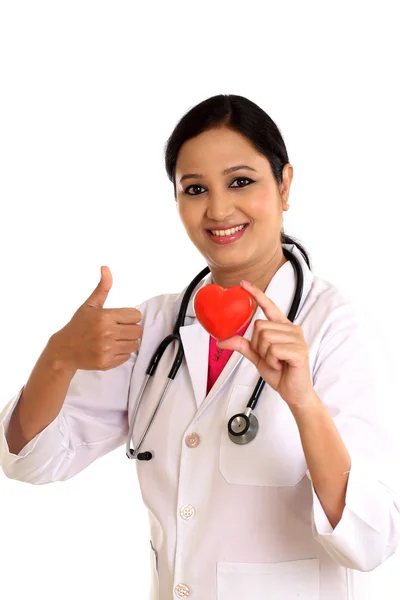 Happy young female doctor holding a beautiful red heart shape — Stock Photo, Image