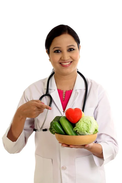 Young female nutritionist doctor holding bowl of vegetables — Stock Photo, Image