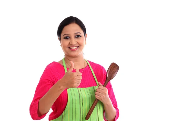 Happy young woman holding kitchen utensil against white backgrou — Stock Photo, Image