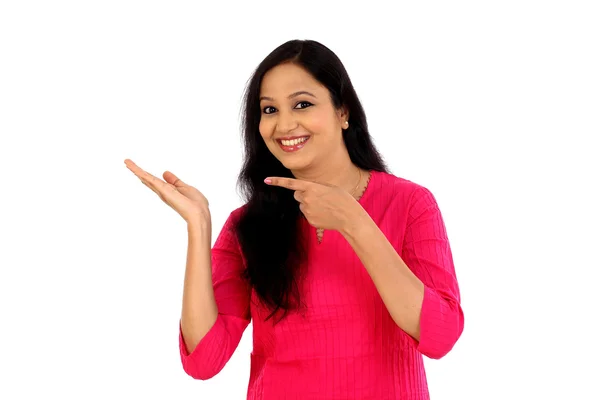 Surprised young woman pointing at a product — Stock Photo, Image