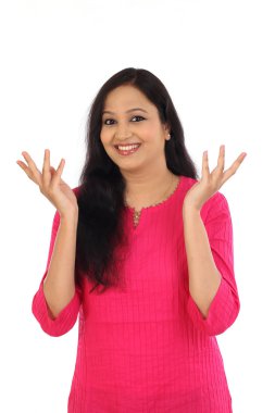 Heyecanlı genç Hintli kadın beyaz bir arka plana dayanır