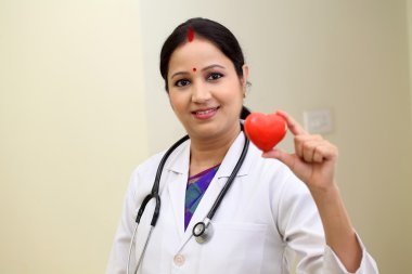 Kırmızı kalp şekli tutan geleneksel kadın doktor