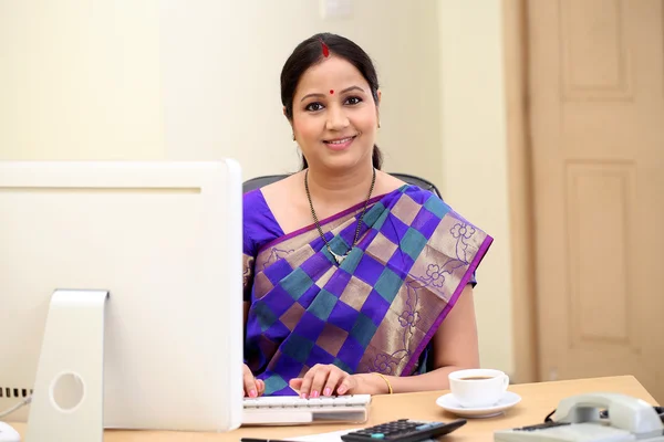 Happy traditional Indian business woman at office desk — Stock Photo, Image