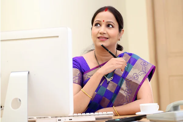 Mujer de negocios tradicional pensando en su escritorio —  Fotos de Stock