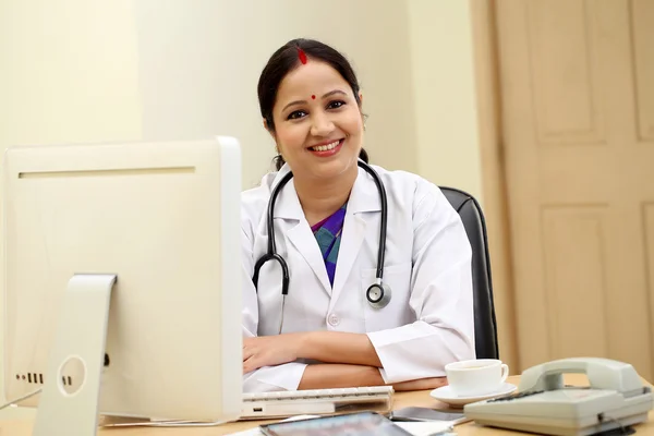 Happy traditional female doctor in hospital interior