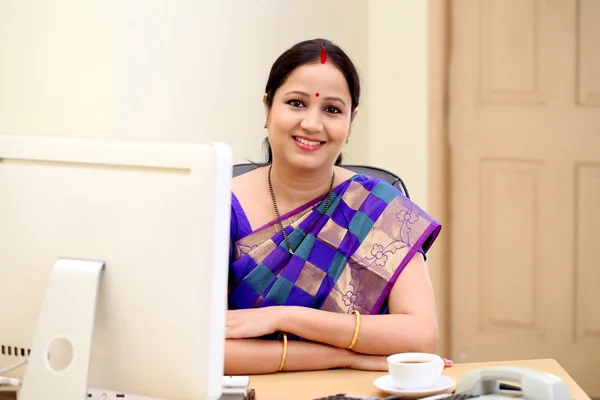 Gelukkig zakenvrouw met traditionele Indiase op Bureau — Stockfoto