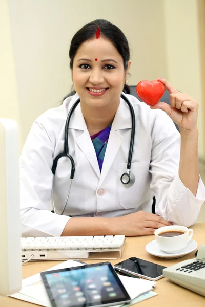 Jeune femme médecin tenant rouge forme de coeur — Photo
