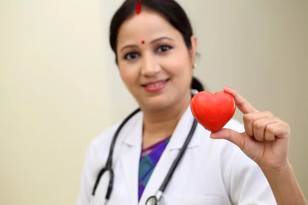 Femeie medic care deține o formă frumoasă a inimii roșii — Fotografie, imagine de stoc