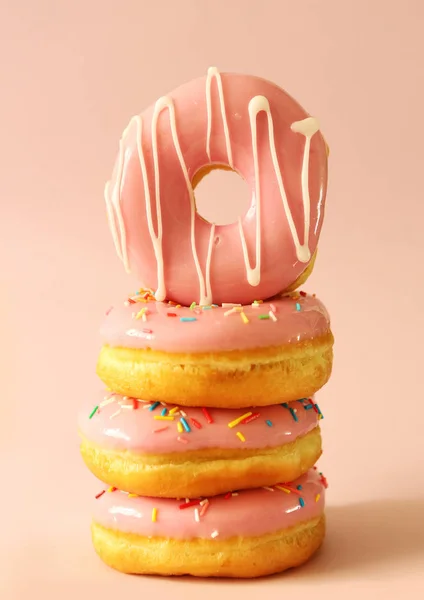 一组釉面甜甜圈 粉色背景的彩色糖霜甜甜圈 — 图库照片