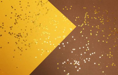 Yıldızlı, soyut, kahverengi ve sarı arka plan. Üzerinde parıldayan yıldızlar olan şenlikli kağıt arka plan.