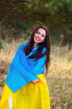 Güzel esmer model bir park Ukrayna bayrağı ile poz