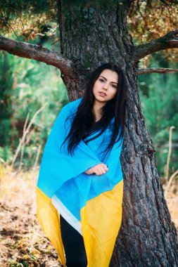 Güzel esmer model bir park Ukrayna bayrağı ile poz