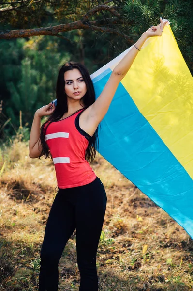 Красива брюнетка модель постановки в парку з прапор України — стокове фото