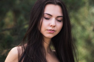 Zarif çekici esmer model iğne yapraklı Park siyah elbise poz