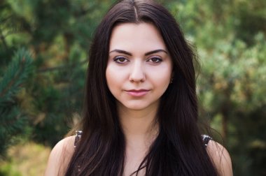 Zarif çekici esmer model iğne yapraklı Park siyah elbise poz