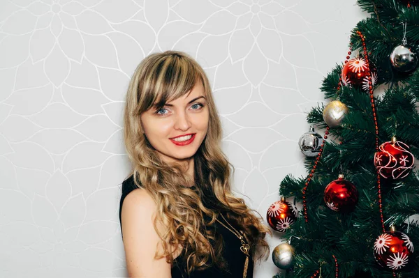 Schöne Blondine in der Nähe eines Weihnachtsbaums. — Stockfoto