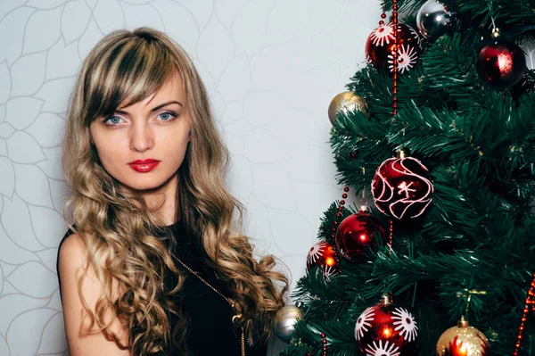 Schöne Blondine in der Nähe eines Weihnachtsbaums. — Stockfoto