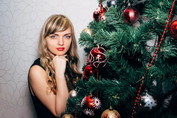 Schöne Blondine in der Nähe eines Weihnachtsbaums. — Stockfoto