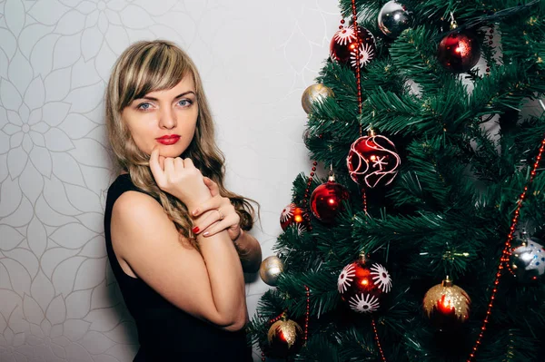 Schöne Blondine in der Nähe eines Weihnachtsbaums. — Stockfoto