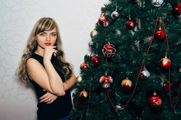 Schöne Blondine in der Nähe eines Weihnachtsbaums. — Stockfoto