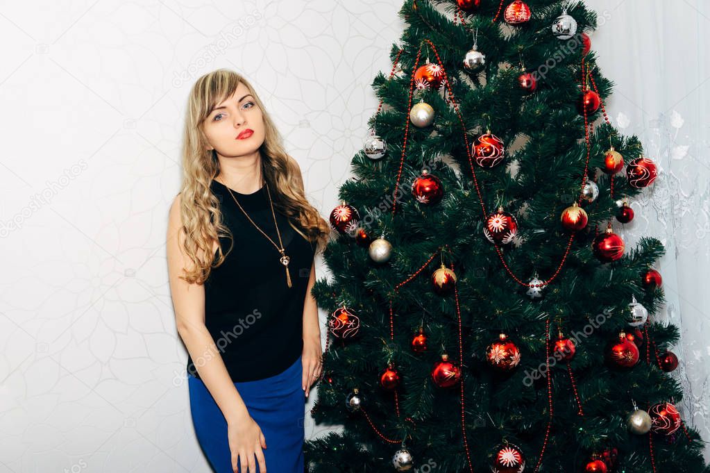 Beautiful blonde near a Christmas tree.