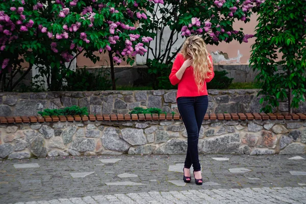 Mädchen posiert gegen blühenden violetten Flieder — Stockfoto