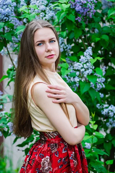 Pretty girl with posing at garden against blooming lilac. — Stock Photo, Image