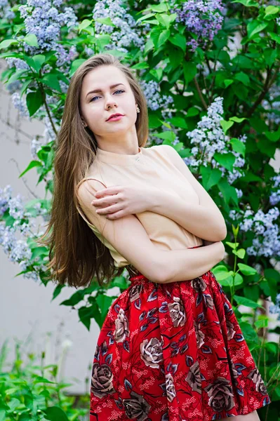ブルーミング ライラックに対して庭でポーズかわいい女の子. — ストック写真