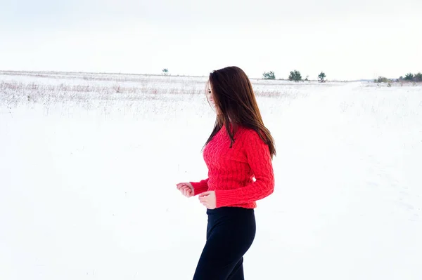 Meisje in de winter op een besneeuwde veld. — Stockfoto