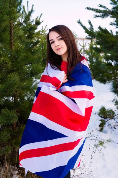 Der Winter des Mädchens im Park ist in eine britische Flagge gehüllt — Stockfoto