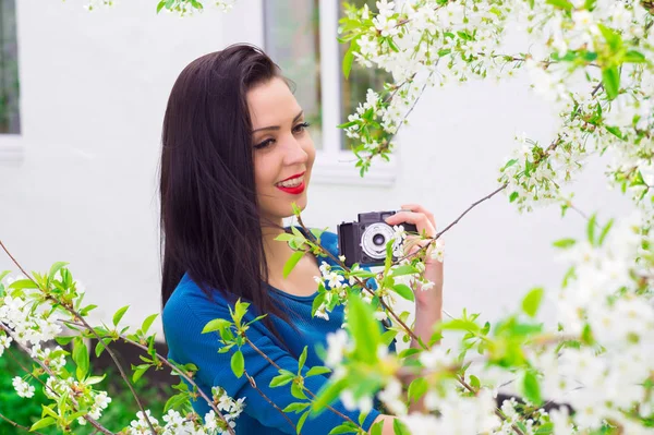 Una joven con cámara retro fotografiando un vestido azul — Foto de Stock