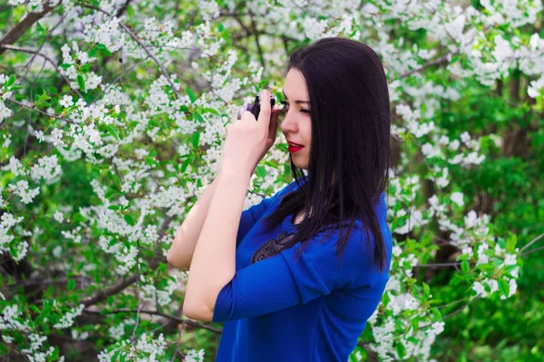 Una joven con cámara retro fotografiando un vestido azul — Foto de Stock