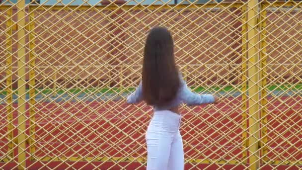 Güzel Genç Kız Kamera Gülümseyen Eğleniyor Arka Planda Sarı Çit — Stok video